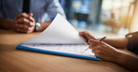 Woman signing papers in law office