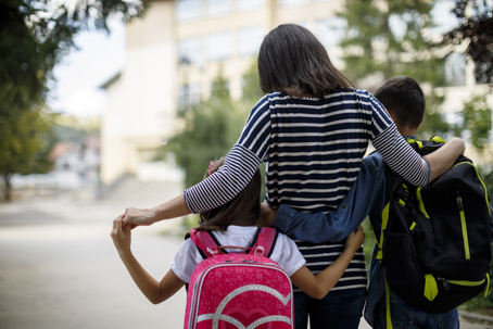 mother and children walking to school