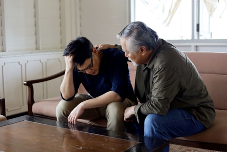 Dad consoling grown son