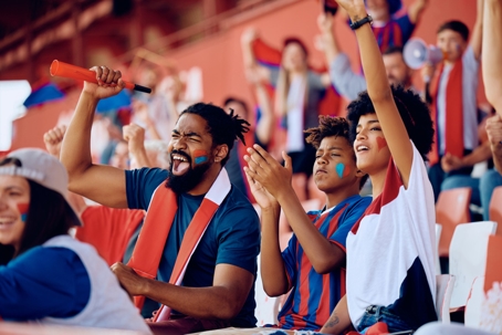 family cheering from bleachers during a game
