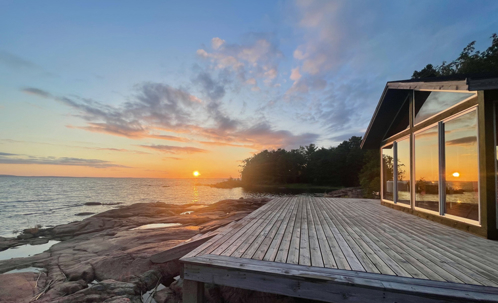 exterior of a house by the sea during sunset