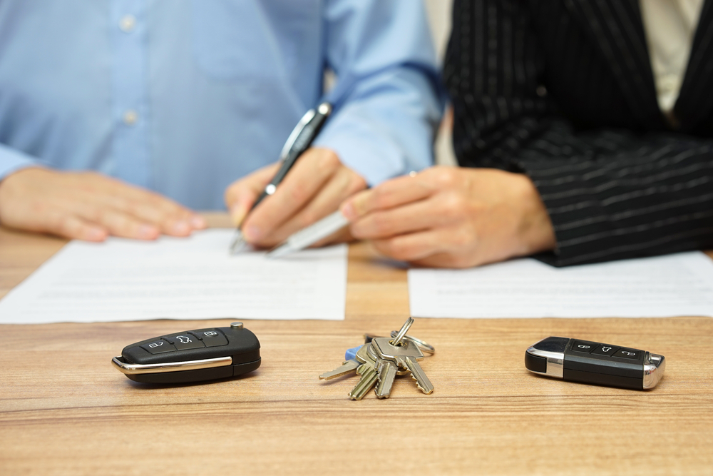Two people sitting next to each other with house keys between them and car keys on either side using California divorce laws